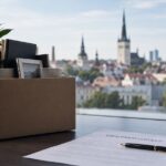 Employment termination in Estonia – cardboard box with personal belongings and an employment contract in a Tallinn office.